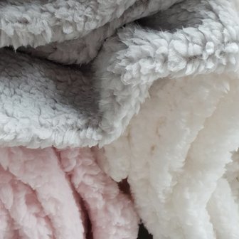 wit fluffie teddy naast grijs en roze