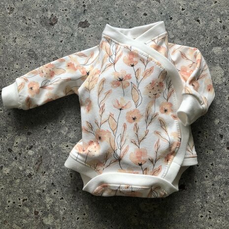 baby rompertje perzik bloemen gemaakt door klant van KicKenStoffen