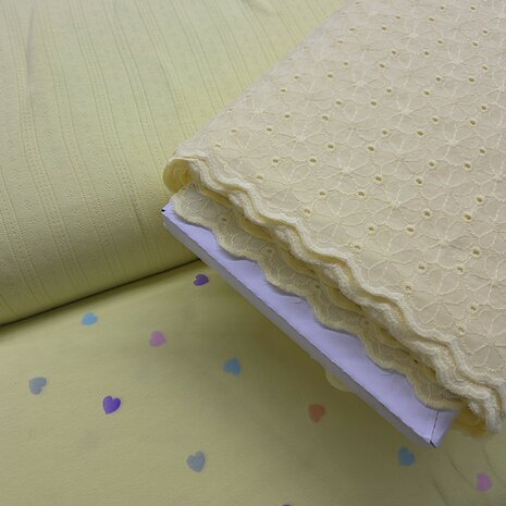 gele pointelle tricot en hartjes tricot en broderie schulprand kickenstoffen